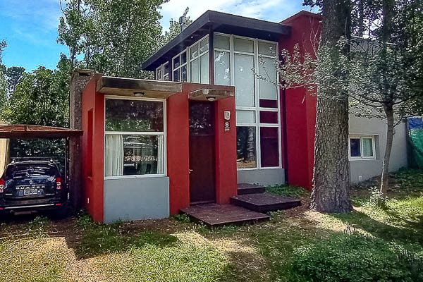 Fachada moderna de Casa El Rayo Verde rodeada de pinos en Mar Azul.