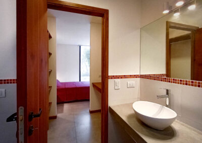 Baño principal de Casa Moby Dick en Mar Azul con bacha moderna, monocomando y vista hacia el dormitorio principal.