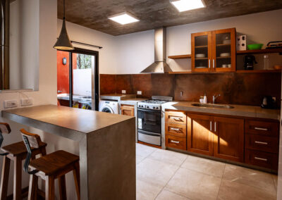 Cocina moderna y equipada de Casa Moby Dick en Mar Azul, con barra de hormigón y mobiliario de madera