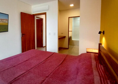 Dormitorio principal de Casa Moby Dick en Mar Azul, con baño en suite y vista al bosque