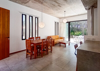 Living comedor moderno de Casa Moby Dick en Mar Azul, con ventanales al bosque y decoración minimalista.